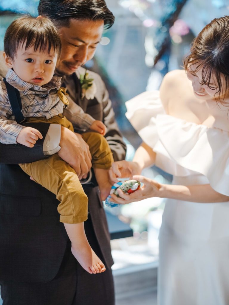 福岡のフリープランナーによるレストランウエディングで、新郎新婦がお子様に草鞋を履かせる様子